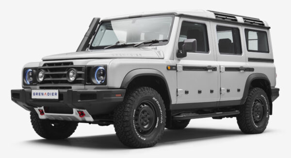 Szary Grenadier - surowy terenowy SUV. Solidny, kwadratowy kształt, duże opony i wytrzymały wygląd.